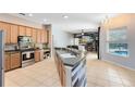 Open kitchen with an island, stainless steel appliances, and view to the living room and pool at 640 Brookfield Pl, Apopka, FL 32712