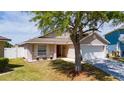 Charming home with a front porch, two-car garage and well-kept lawn providing lovely curb appeal at 654 Chadbury Way, Kissimmee, FL 34744