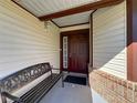 Inviting entryway features a decorative welcome bench and a solid wood front door at 6559 Grosvenor Ln, Orlando, FL 32835