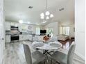 Open-concept kitchen with stainless steel appliances and a dining area, leading to a living room at 6559 Grosvenor Ln, Orlando, FL 32835