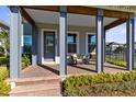 Cozy front porch with comfortable seating, creating an inviting entrance with meticulously landscaped garden in view at 6665 Bridgman St, Orlando, FL 32827