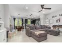 Open concept living room boasts tile floors, modern furnishings, and lots of natural light at 6983 Tussilago Way, Orlando, FL 32822