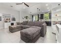 Spacious living room featuring tile floors, sectional sofa, and view into kitchen at 6983 Tussilago Way, Orlando, FL 32822