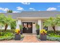 Elegant front entrance with double doors, lush landscaping, and stylish planters creating a welcoming appeal at 7455 Sparkling Lake Rd, Orlando, FL 32819