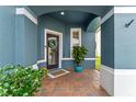 Inviting front porch with brick flooring, colorful plants, and a wreath-adorned door at 820 Timber Isle Dr, Orlando, FL 32828