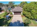 Charming single-story home with a manicured lawn, a two-car garage, and a golf cart parked in the driveway at 1 Huntley Ct, Haines City, FL 33844