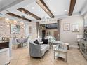 Luxurious living room with elegant furnishings, stone accent wall and decorative beams leading to an outdoor patio at 10765 Village Lake Rd, Windermere, FL 34786