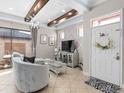 Elegant living room featuring stylish decor, beamed ceiling and seamless access to an outdoor patio at 10765 Village Lake Rd, Windermere, FL 34786