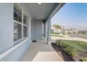 Welcoming covered front porch with modern gray walls, providing curb appeal and shade at 11279 Amber Ridge Dr, Zellwood, FL 32798