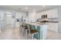 Kitchen with white cabinets, granite countertops, stainless steel appliances and a large island with barstool seating at 11279 Amber Ridge Dr, Zellwood, FL 32798