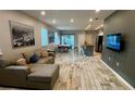 Open concept living room featuring wood-look flooring and a cozy sectional sofa at 118 Hurst Ct, Deland, FL 32724