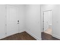 Bright entryway featuring wood-look flooring and a white door leading to a bathroom with tile floor and modern fixtures at 13528 Autumn Harvest Ave, Winter Garden, FL 34787