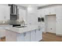 Modern kitchen featuring white cabinets, stainless steel appliances, a stylish backsplash, and an island at 13528 Autumn Harvest Ave, Winter Garden, FL 34787