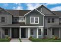 Gray two-story townhome boasts a welcoming covered entryway at 13536 Autumn Harvest Ave, Winter Garden, FL 34787