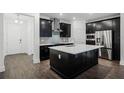 Spacious kitchen featuring dark cabinets, stainless appliances, and a central island with quartz countertop at 13536 Autumn Harvest Ave, Winter Garden, FL 34787