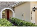 Close up of the front door, with address numbers, landscape and a stone facade at 14040 Helsby St, Orlando, FL 32832