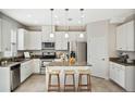 Bright kitchen with granite countertops, stainless steel appliances, island with seating, and white cabinetry at 14040 Helsby St, Orlando, FL 32832