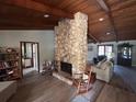 Spacious living room showcasing a striking stone fireplace and wood-look flooring at 1500 Markham Woods Rd, Longwood, FL 32779