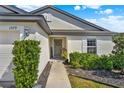 Charming home entrance with a walkway, lush shrubs and a welcoming front door at 1579 Swan Lake Cir, Dundee, FL 33838