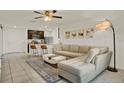 Open living room with tile floors, neutral tones, ceiling fan and breakfast bar at 1579 Swan Lake Cir, Dundee, FL 33838