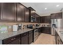 Stylish kitchen with stainless steel appliances, granite countertops, and dark brown cabinets at 1639 Lima W Ave, Kissimmee, FL 34747