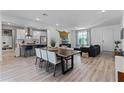 Bright, open-concept living space boasts wood floors, modern lighting, and seamlessly connects to the kitchen at 1806 Paloma Ave, Sanford, FL 32771