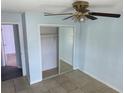 Bedroom with mirrored closet doors, ceiling fan and tile flooring at 214 Magellan Dr, Kissimmee, FL 34758
