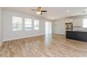 Spacious living room with wood-look tile floors, plenty of natural light, ceiling fan, and an adjacent modern kitchen at 2430 Sanderling St, Haines City, FL 33844