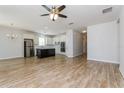 Open-concept living area showcasing wood-look tile floors, a modern kitchen with stainless appliances, and a ceiling fan at 2430 Sanderling St, Haines City, FL 33844