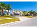 Beautiful two-story home with a two-car garage, green lawn, and elegant palm tree landscaping at 2659 Calistoga Ave, Kissimmee, FL 34741