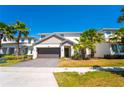 Attractive two-story home with a two-car garage, complemented by green grass and swaying palm trees at 2659 Calistoga Ave, Kissimmee, FL 34741