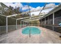 Screened-in pool with steps, surrounding concrete deck, and enclosed by a white frame at 38851 Forest Dr, Eustis, FL 32736