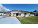 Charming single-story home featuring a red tile roof and stucco exterior, complemented by lush landscaping at 39 Fellowship Dr, Palm Coast, FL 32137