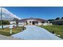 Charming single-story home with tile roof, stucco, and a painted driveway leading to an attached garage at 39 Fellowship Dr, Palm Coast, FL 32137