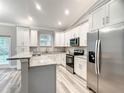 Modern kitchen featuring stainless steel appliances, granite countertops, and ample white cabinetry for storage at 501 Mulberry St, Fruitland Park, FL 34731