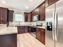 Updated kitchen features dark wood cabinets, stainless steel appliances, and granite countertops at 509 Mulberry St, Fruitland Park, FL 34731