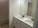 Bathroom featuring double sinks with quartz countertop, white cabinetry, and tile flooring and shower/tub at 618 Duke Dr, Haines City, FL 33844