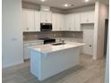 Bright kitchen with white cabinetry, stainless steel appliances, island with quartz countertop, and subway tile backsplash at 618 Duke Dr, Haines City, FL 33844