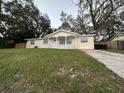 Traditional-style home featuring a green lawn and a driveway in a quiet neighborhood at 6427 Breezewood St, Orlando, FL 32818