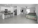 Open-concept kitchen and living area with stainless steel appliances and gray tile flooring at 660 Silver Palm Dr, Haines City, FL 33844