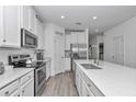 Bright kitchen featuring stainless steel appliances, a large island, white cabinets, and tiled floors at 7536 Sw 77Th Ave, Ocala, FL 34481