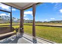 Inviting screened-in porch featuring comfortable wicker furniture and serene views of the expansive green space at 7536 Sw 77Th Ave, Ocala, FL 34481