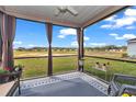 Relaxing screened-in porch with comfortable seating and a view of the community's green space beyond the fence at 7536 Sw 77Th Ave, Ocala, FL 34481