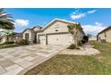 Charming single-story home with lush landscaping, a paver driveway, and a two-car garage at 9210 Sw 60Th Court Rd, Ocala, FL 34476