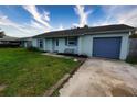 Single story home with light blue painted facade, attached garage, and well manicured lawn and landscape at 1491 Lavender St, Deltona, FL 32725