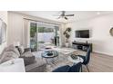 This comfortable living room features a ceiling fan, neutral decor, and sliding doors that lead to the pool area at 17228 Blessing Dr, Clermont, FL 34714