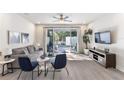 Bright living room featuring modern furniture, a ceiling fan, and sliding glass doors to the private lanai at 17228 Blessing Dr, Clermont, FL 34714