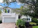 Beautiful two-story home with attached two-car garage and lush landscaping at 1790 Sawyer Palm Pl, Kissimmee, FL 34747