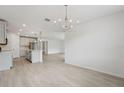 Open-concept dining and kitchen area with wood-look floors and stylish lighting fixtures at 2352 Citrus Bloom Dr, Bartow, FL 33830