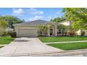 Charming single-story home featuring a manicured lawn, arched entryway, and two-car garage at 2412 Stone Cross Cir, Orlando, FL 32828